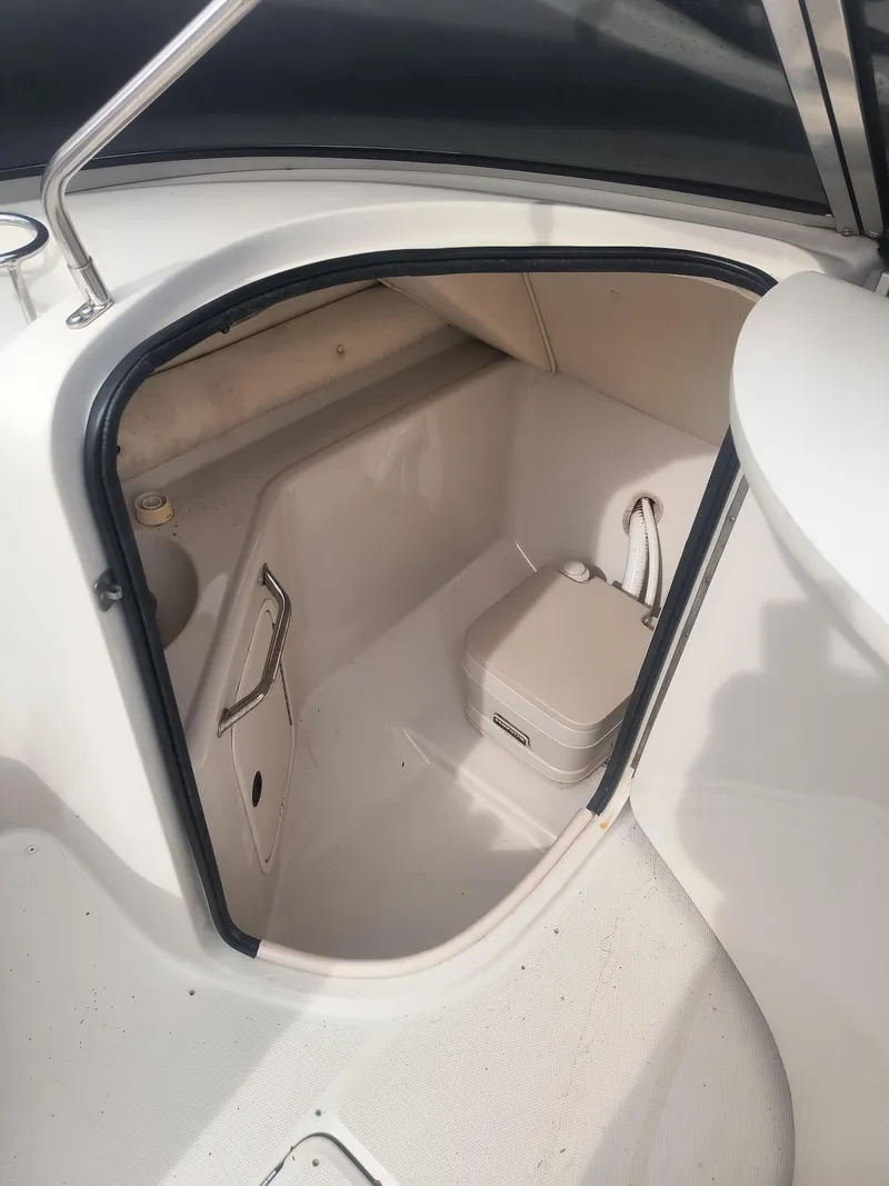 Slide: The Image of 2004 Sea Ray 240 Sundeck interior with compact marine toilet. - 7