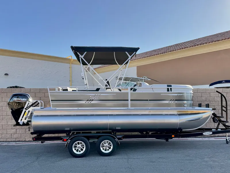 The Image of 2025 Berkshire 20 CRSE pontoon boat on trailer, featuring sleek design and Mercury outboard motor. - 0