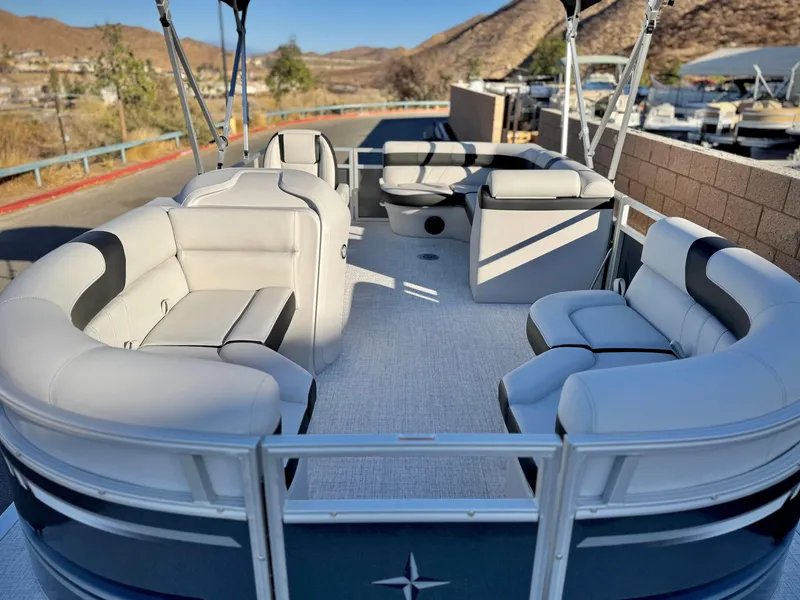 Slide: The Image of 2025 Berkshire 20 CRSE pontoon boat with spacious seating and scenic marina backdrop. - 7