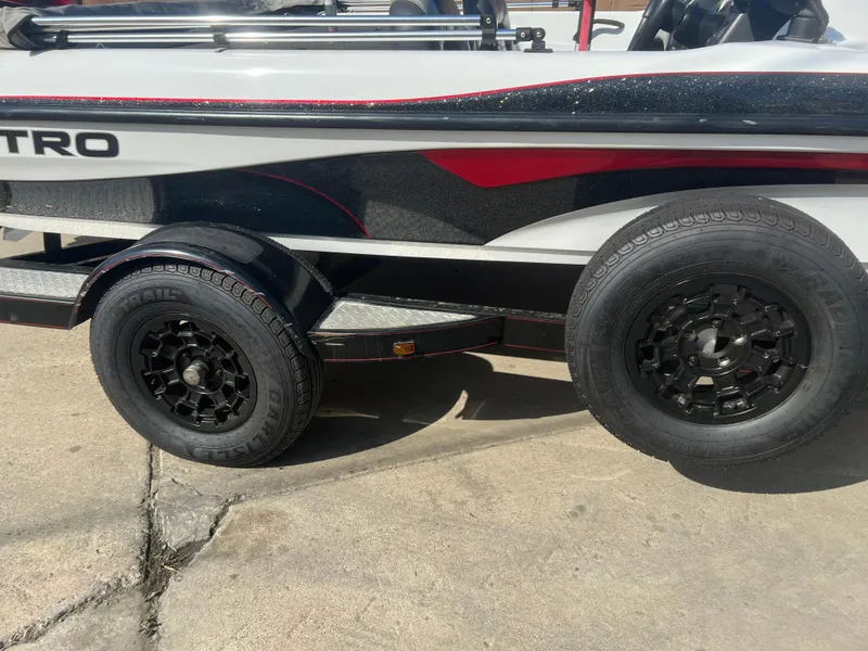 Slide: The Image of 2005 Nitro NX 882 DC boat trailer with black wheels on concrete surface. - 22