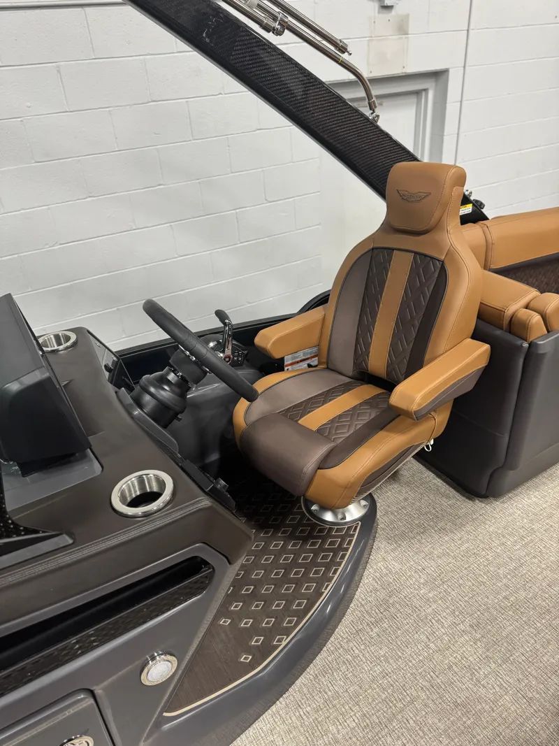 Slide: The Image of Steering wheel and dashboard of 2025 Bennington 24 MFB boat, featuring modern controls and display. - 10