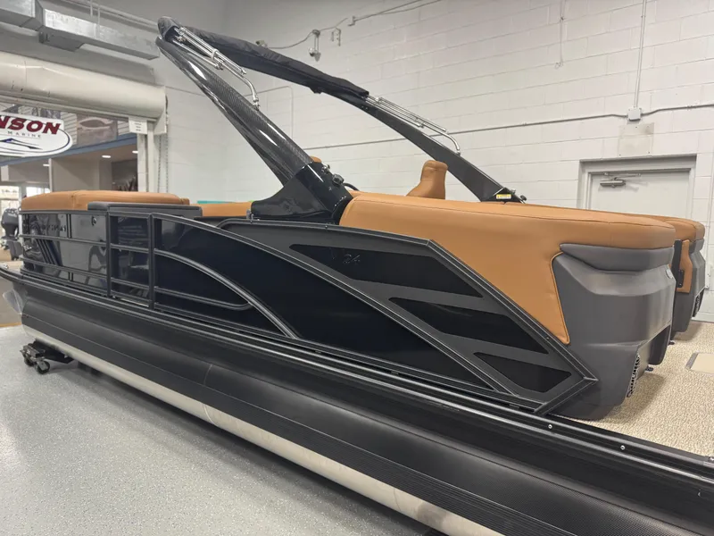Slide: The Image of 2025 Bennington 24 MFB pontoon boat with tan seating in a showroom. - 2
