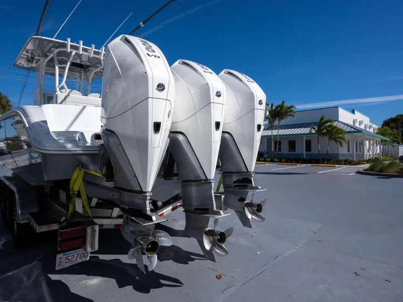 Slide: The Image of 2023 Yellowfin 36 Center Console boat with triple outboard engines, parked on a sunny day. - 25
