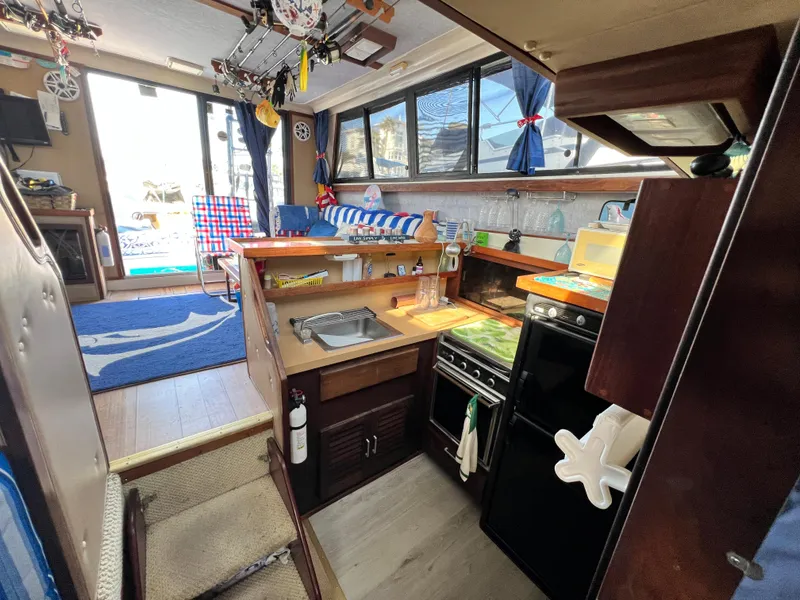 Slide: The Image of Interior of 1982 Silverton 37 Convertible boat with kitchen and seating area. - 11