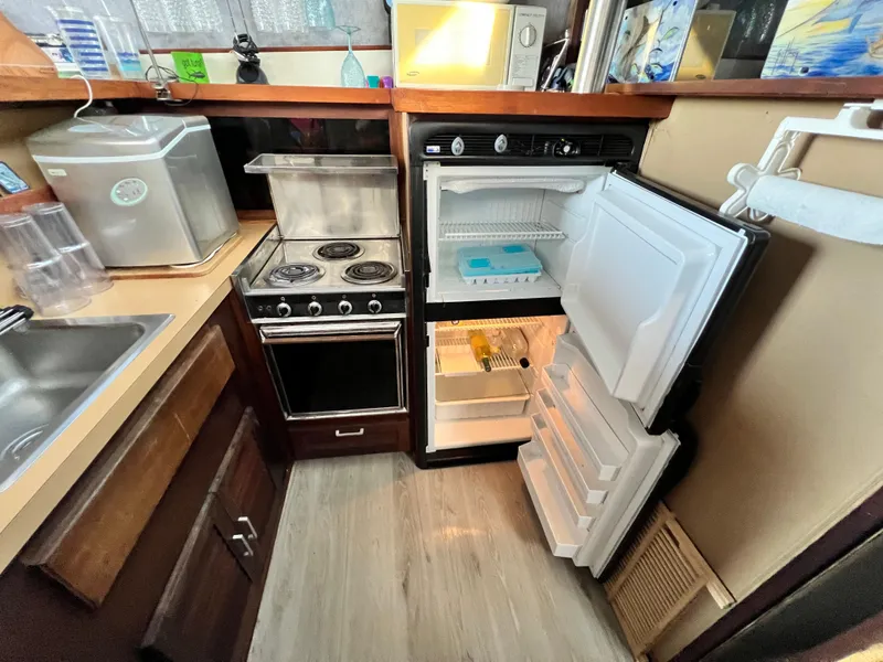 Slide: The Image of 1982 Silverton 37 Convertible kitchen with stove, open fridge, and microwave. - 13