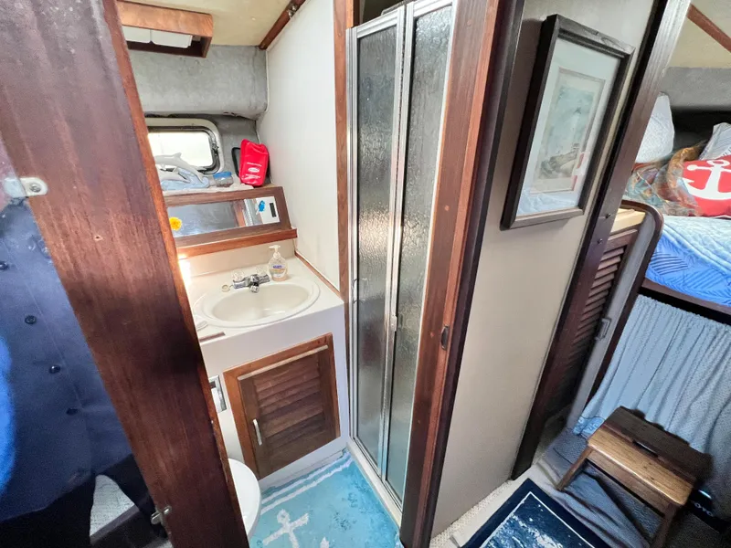 Slide: The Image of 1982 Silverton 37 Convertible bathroom with shower, sink, and nautical decor. - 18
