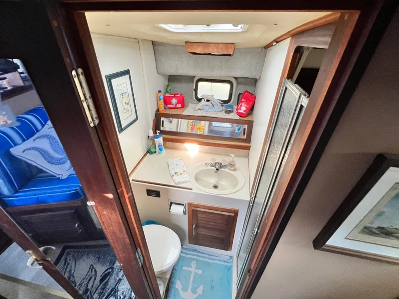 Slide: The Image of 1982 Silverton 37 Convertible bathroom with sink, toilet, and nautical decor. - 19