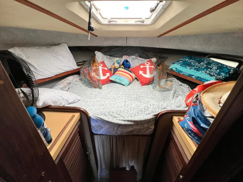 Slide: The Image of 1982 Silverton 37 Convertible cabin with bed, nautical decor, and overhead hatch. - 21