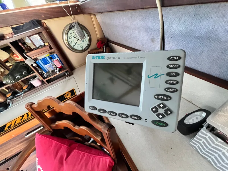 Slide: The Image of Fishfinder on 1982 Silverton 37 Convertible boat interior with clock and shelves. - 9