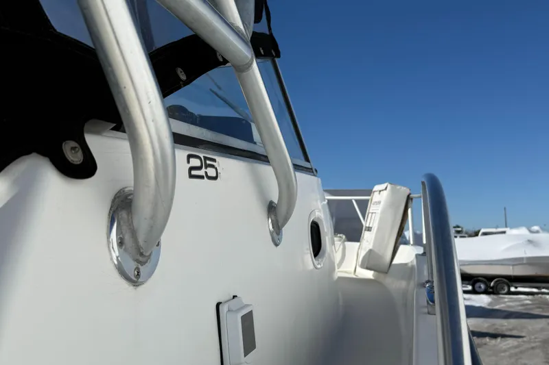 Slide: The Image of 2000 Mako 253 Walk Around boat, close-up view of railing and hull details. - 12