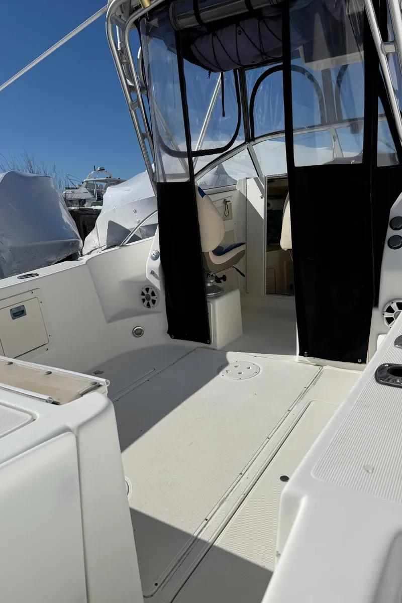 Slide: The Image of 2000 Mako 253 Walk Around boat interior with open cockpit and seating area. - 7