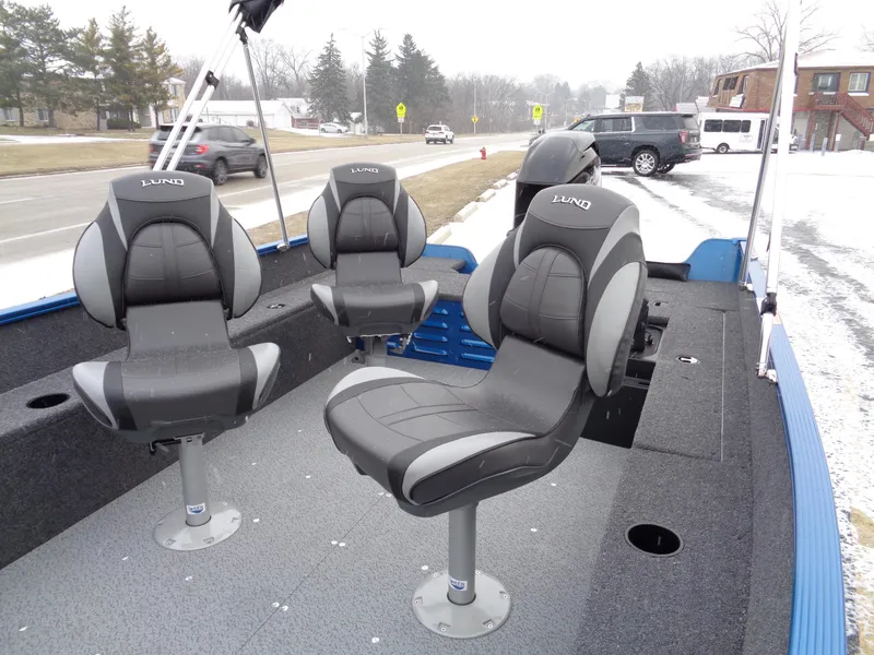 Slide: The Image of 2024 Lund 1650 Angler Tiller boat interior with three swivel seats on a snowy day. - 11