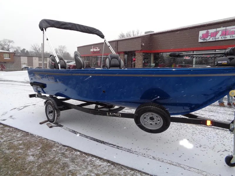 Slide: The Image of 2024 Lund 1650 Angler Tiller boat on trailer in snowy setting. - 3