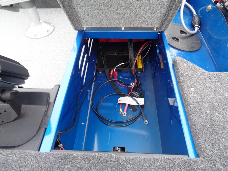Slide: The Image of 2024 Lund 1650 Angler Tiller battery compartment with wiring and storage space. - 9