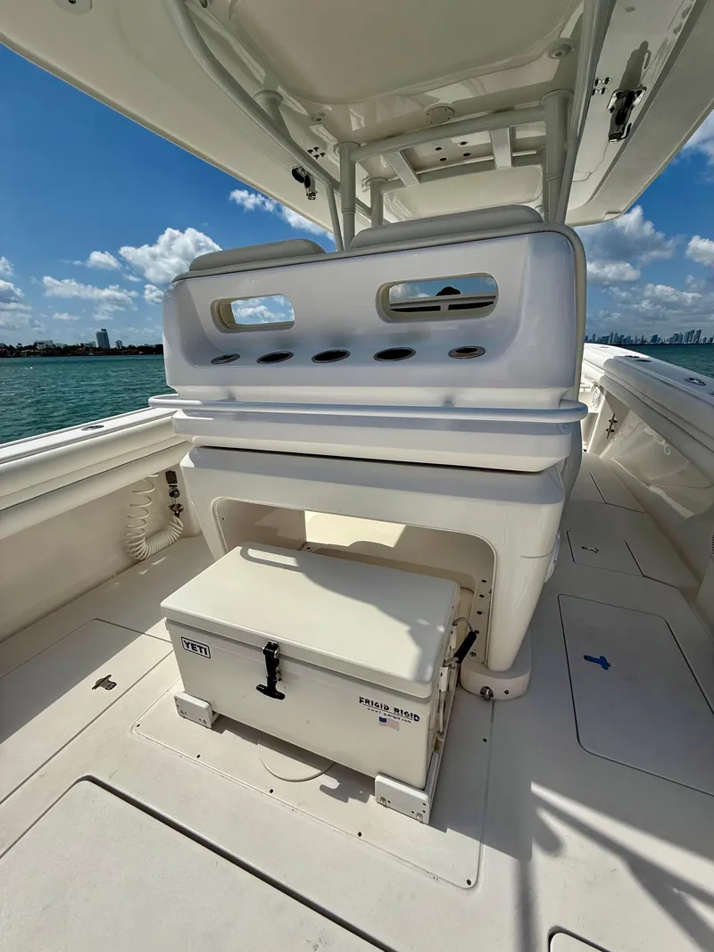 Slide: The Image of 2015 Intrepid 375 Center Console boat interior with seating and storage, under a clear blue sky. - 17
