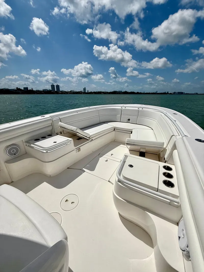 Slide: The Image of 2015 Intrepid 375 Center Console boat with spacious seating, under a bright blue sky. - 24