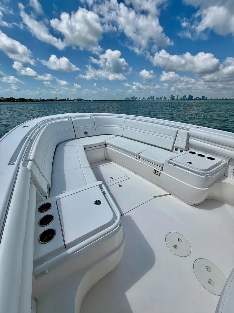 Slide: The Image of 2015 Intrepid 375 Center Console boat with spacious seating, on calm waters under a partly cloudy sky. - 25
