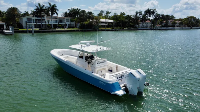Slide: The Image of 2015 Intrepid 375 Center Console boat on calm water near luxury waterfront homes. - 9