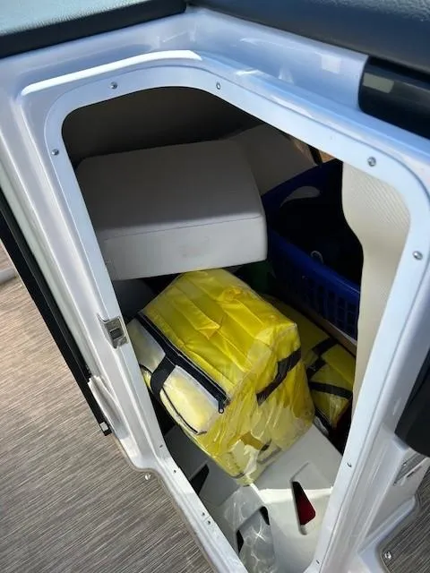 Slide: The Image of Storage compartment of 2018 Four Winns Horizon H290 boat with life jackets and supplies. - 8