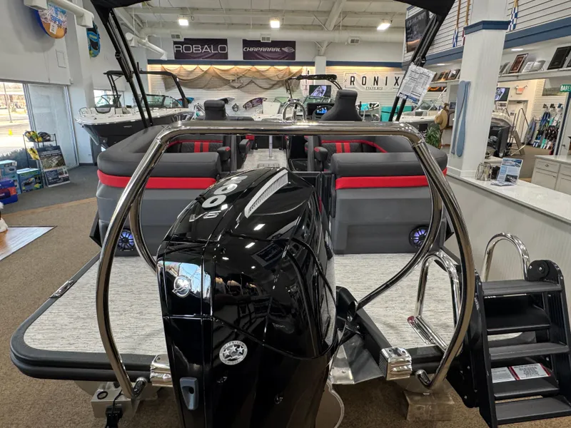 Slide: The Image of 2025 Bennington M Quad Bench 24 MFB pontoon boat in showroom, featuring sleek design and modern seating. - 22