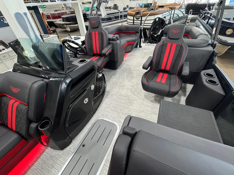 Slide: The Image of 2025 Bennington M Quad Bench 24 MFB boat interior with red-accented seating and modern dashboard. - 6