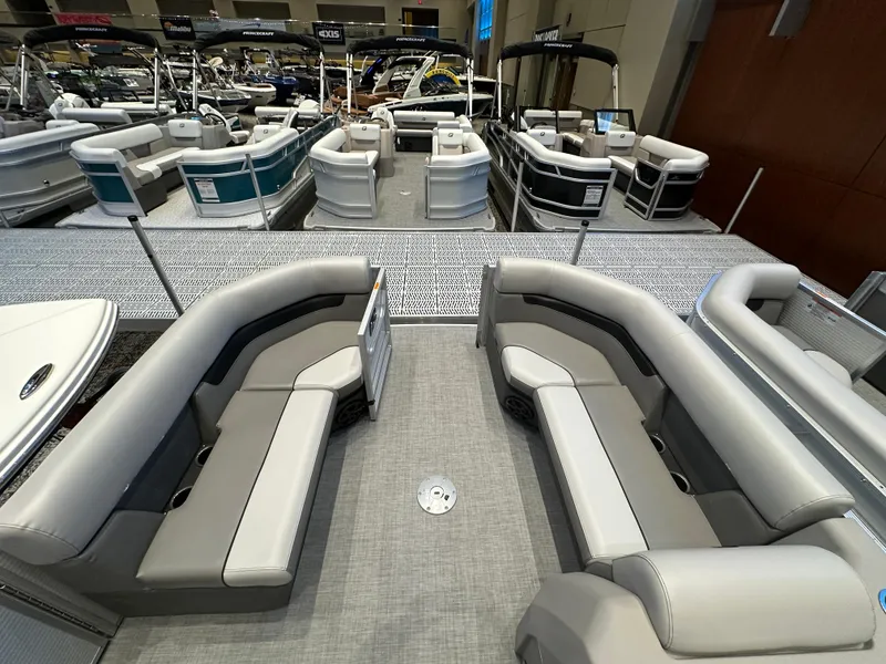 Slide: The Image of 2025 Princecraft Vectra 21 RL pontoon boat with spacious seating at a boat show. - 2