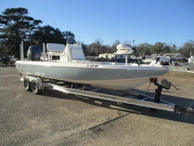 Slide: The Image of 2022 Skeeter SX240 boat on trailer, parked outdoors under clear blue sky. - 4