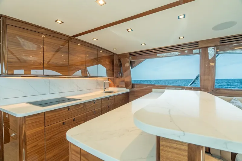 Slide: The Image of Luxurious interior of 2025 Viking 64 Convertible yacht with sleek wood finishes and ocean view. - 16
