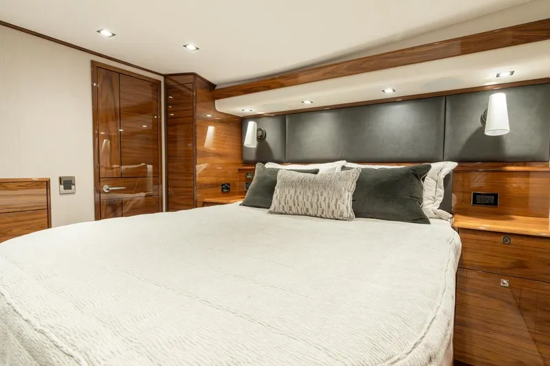 Slide: The Image of Luxurious bedroom interior of 2025 Viking 64 Convertible yacht, featuring elegant wood finishes. - 21