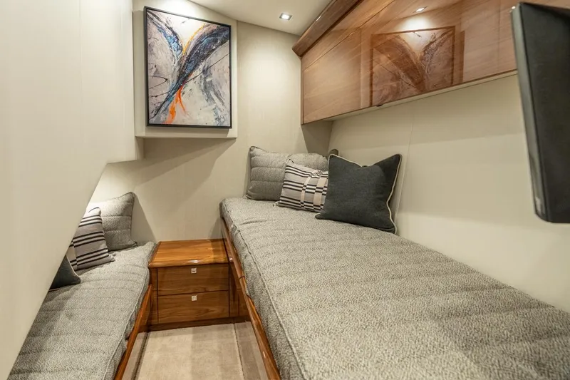Slide: The Image of 2025 Viking 64 Convertible yacht interior with cozy twin beds and modern decor. - 24
