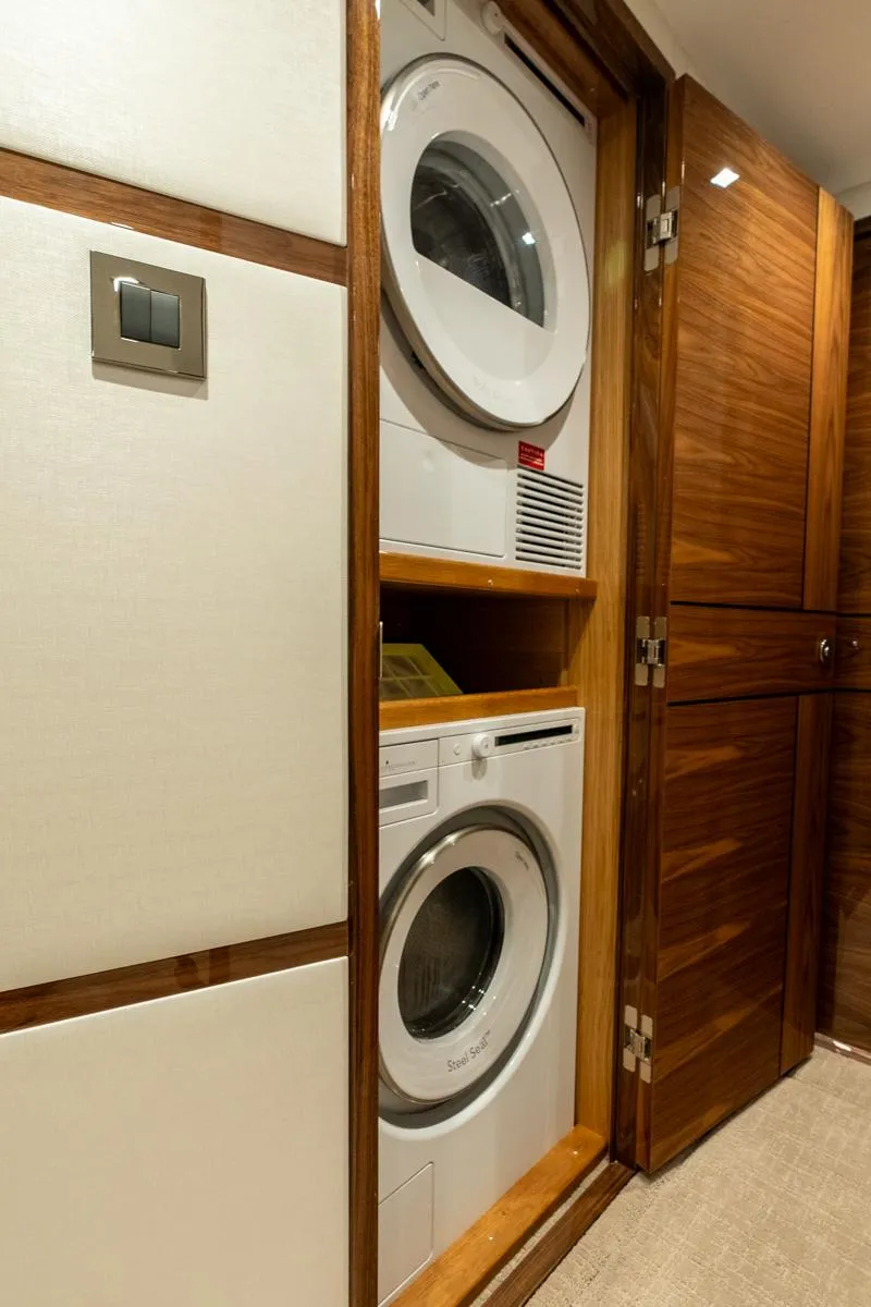 Slide: The Image of Stacked washer and dryer in 2025 Viking 64 Convertible yacht interior. - 25