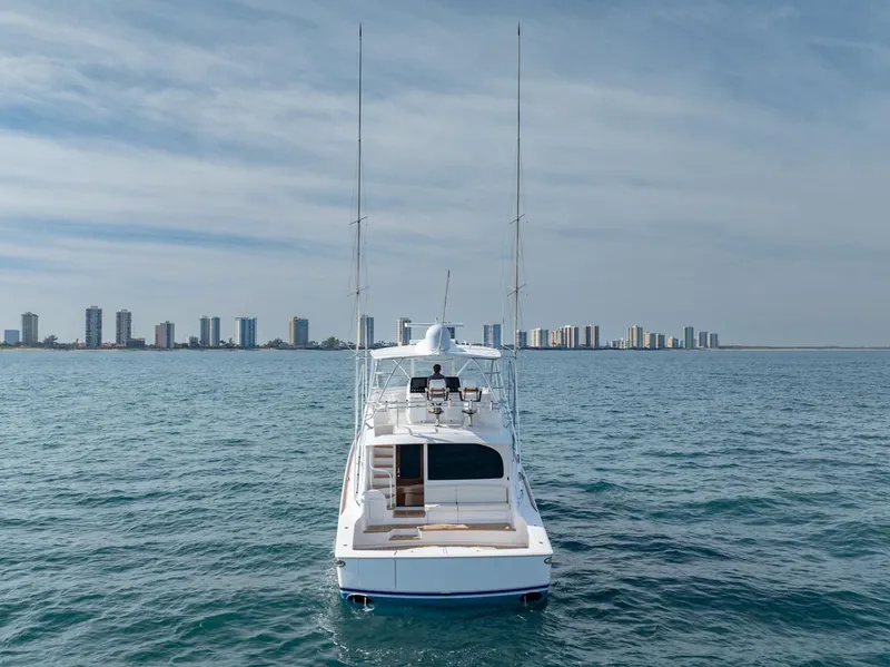 Slide: The Image of 2025 Viking 64 Convertible yacht on open water with city skyline in background. - 28