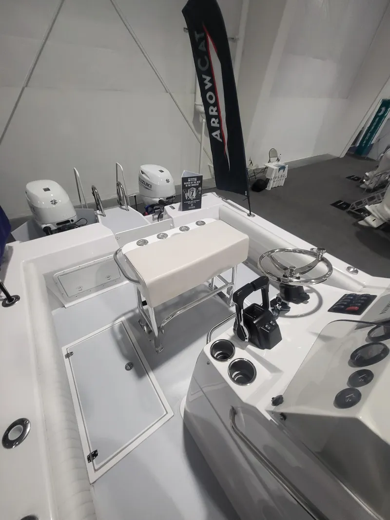 Slide: The Image of 2025 ArrowCat 20CC boat interior with steering console and seating, displayed indoors. - 10