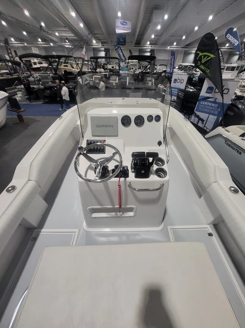 Slide: The Image of 2025 ArrowCat 20CC boat interior at a boat show, featuring steering console and navigation equipment. - 8