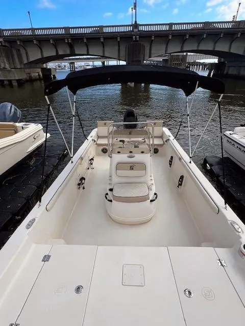 Slide: The Image of 2020 Carolina Skiff 21 LS boat with canopy, docked near a bridge. - 4