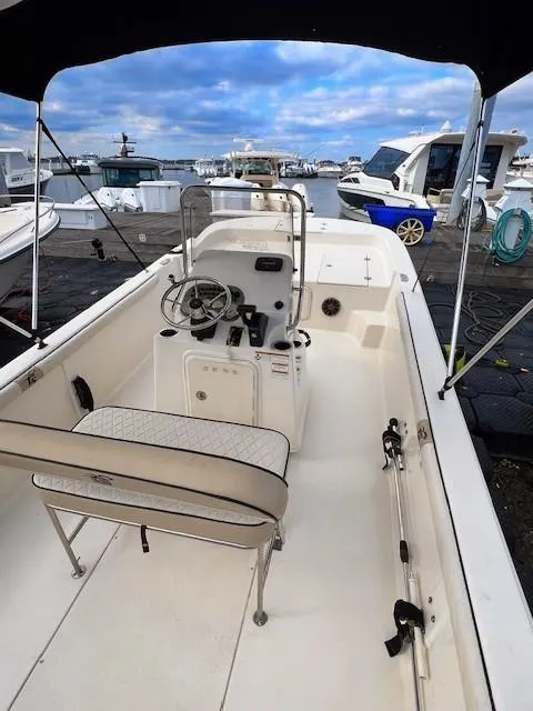 Slide: The Image of 2020 Carolina Skiff 21 LS boat docked, featuring spacious interior and steering console. - 6
