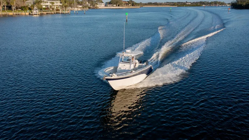 Slide: The Image of Sea Fox 286 Commander 2012 cruising on a serene lake with scenic shoreline. - 24