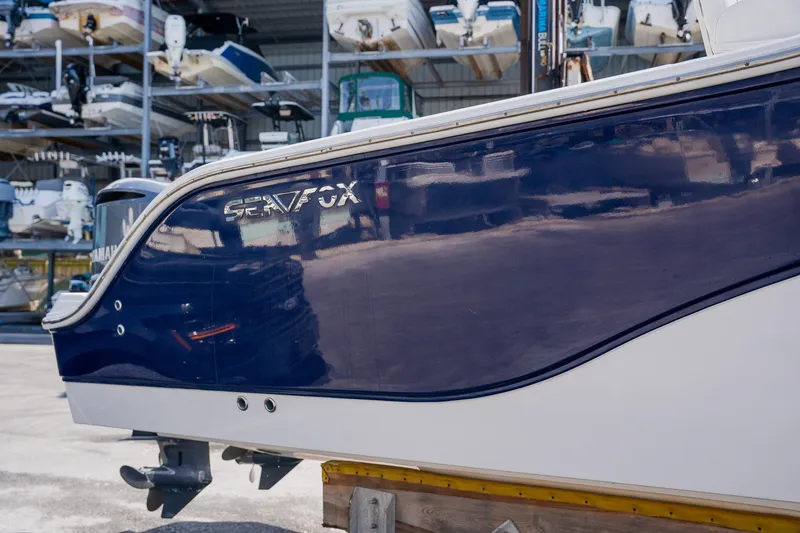 Slide: The Image of 2012 Sea Fox 286 Commander boat hull in storage, showcasing sleek design and blue finish. - 30