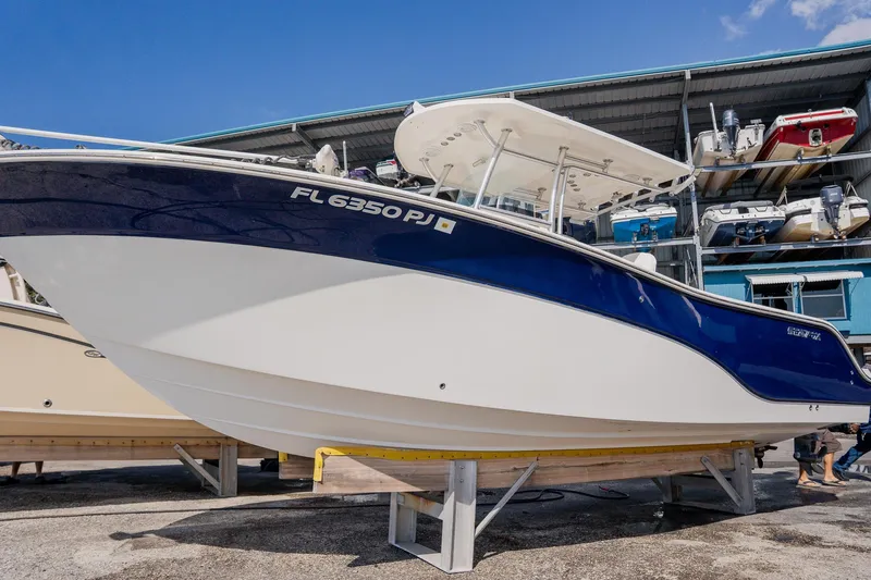 Slide: The Image of 2012 Sea Fox 286 Commander boat on display, blue and white hull, stored on a stand. - 31