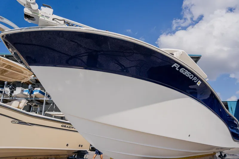 Slide: The Image of 2012 Sea Fox 286 Commander boat with blue and white hull under a clear sky. - 32