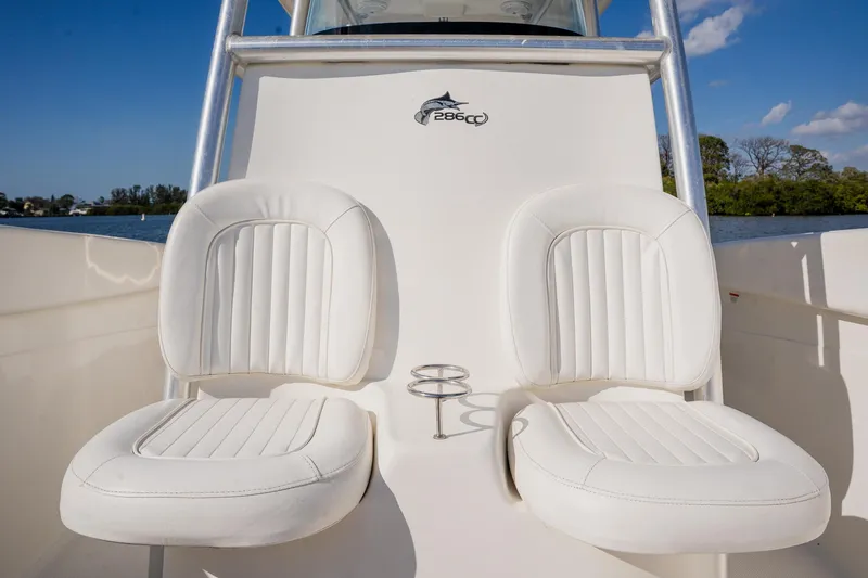 Slide: The Image of 2012 Sea Fox 286 Commander boat with white cushioned seats and scenic background. - 49