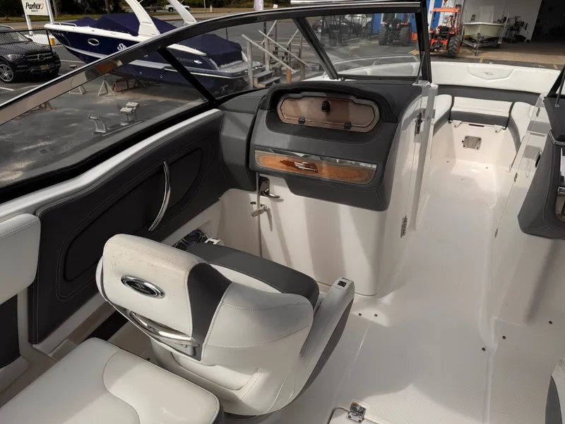 Slide: The Image of 2013 Chaparral 257 SSX boat cockpit with steering wheel and dashboard controls. - 27