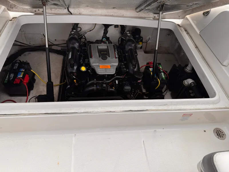 Slide: The Image of 2013 Chaparral 257 SSX boat propeller and drive system, parked near blue wall. - 45