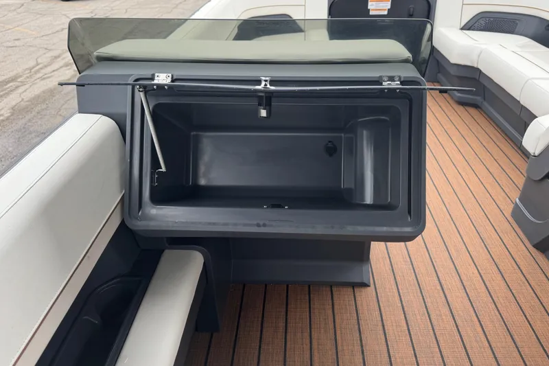 Slide: The Image of 2025 Manitou 24' Explore Switchback boat interior with open storage compartment. - 7