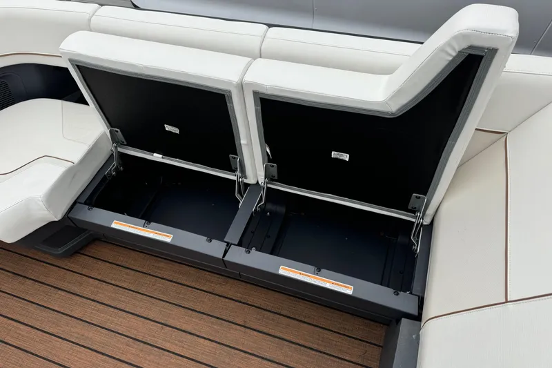 Slide: The Image of 2025 Manitou 24' Explore Switchback boat seating with open storage compartments. - 9