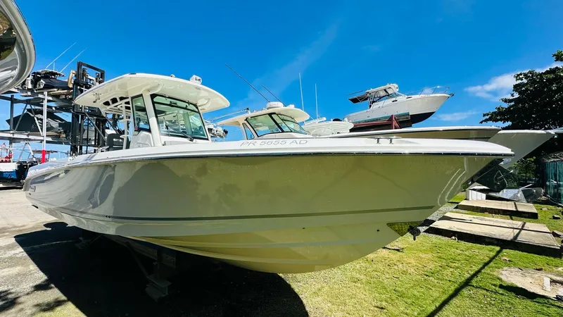 Slide: The Image of 2023 Boston Whaler 330 Outrage boat on display under clear blue sky. - 10