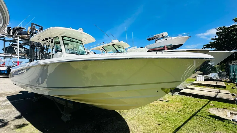 Slide: The Image of 2023 Boston Whaler 330 Outrage boat on display under clear blue sky. - 11