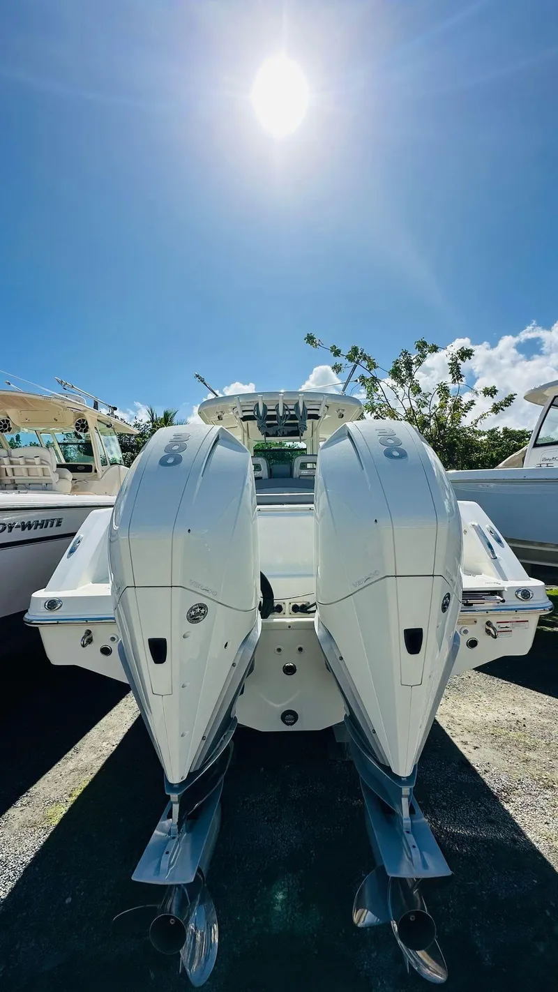 Slide: The Image of 2023 Boston Whaler 330 Outrage boat with dual engines under a bright sunlit sky. - 12