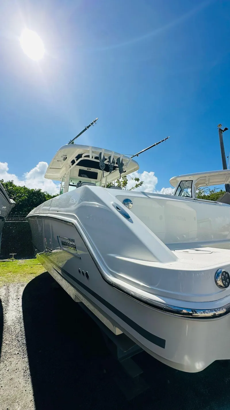 Slide: The Image of 2023 Boston Whaler 330 Outrage boat under clear blue sky. - 13