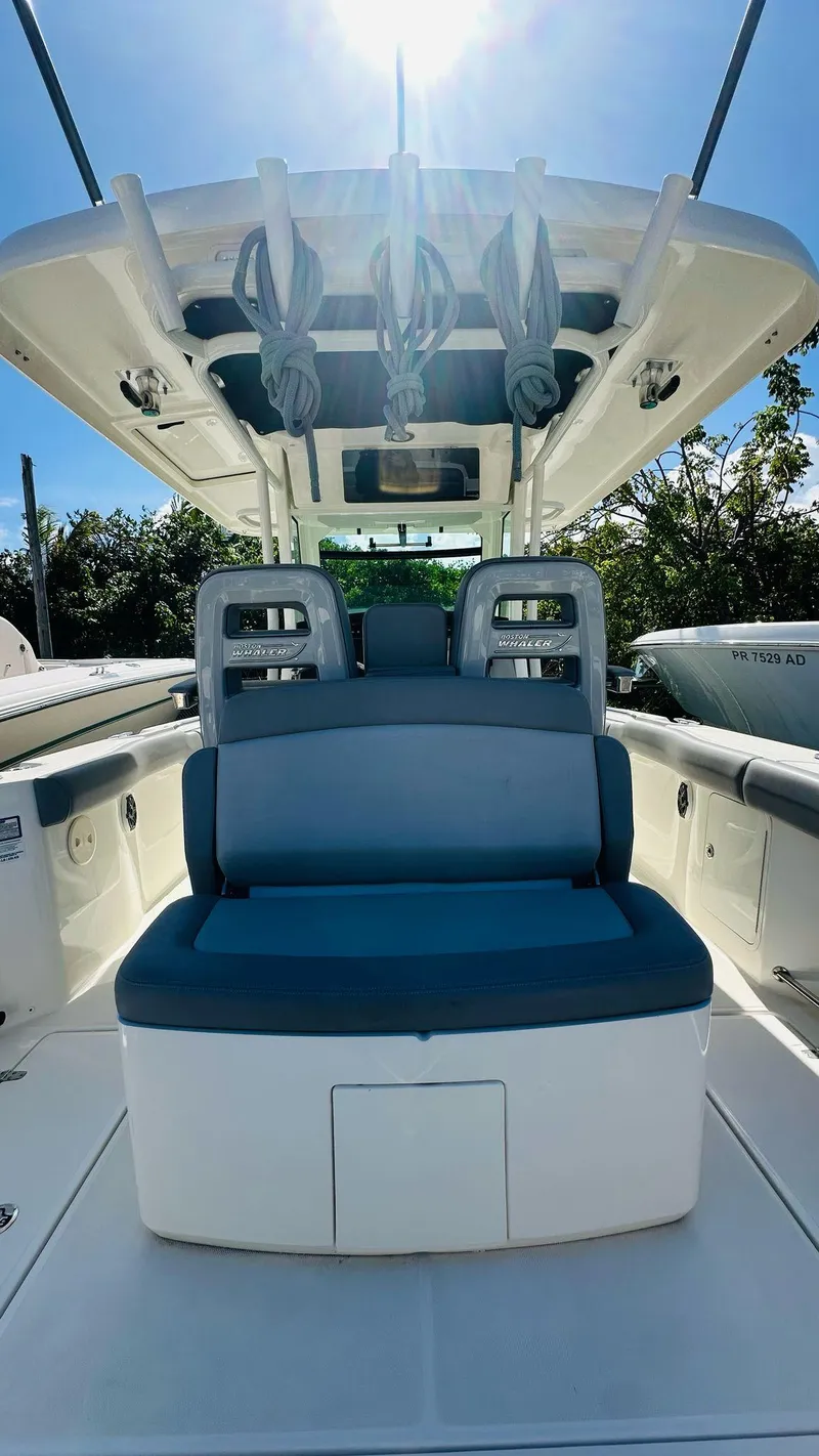 Slide: The Image of 2023 Boston Whaler 330 Outrage boat interior with seating and overhead storage. - 14